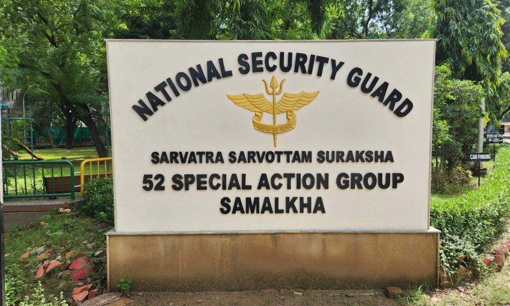 Prominent signboard of the National Security Guard 52 Special Action Group in Samalkha surrounded by lush greenery, captured by the Best Relief Wall Artist in Gurgaon.